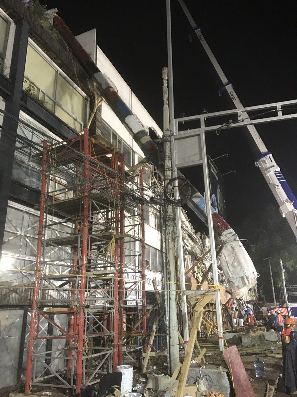 Damaged building at night braced with red steel shoring, Mexico City 2017.